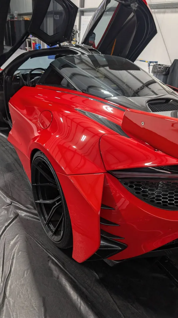 Red McLaren 720S with the doors up in the shop