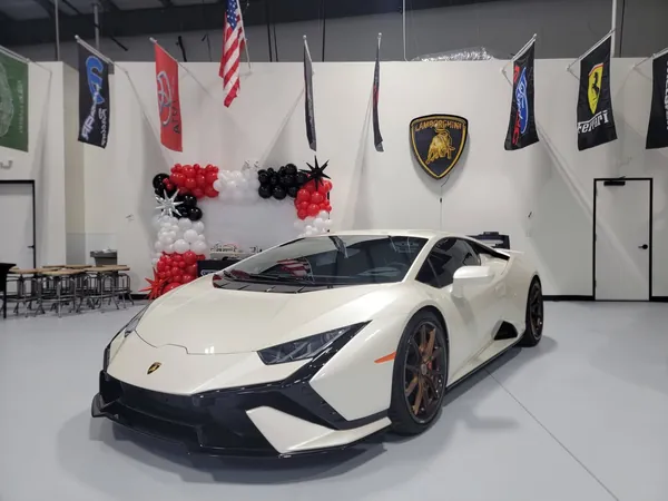 White Lamborghini Huracán in the showroom with balloons and flags