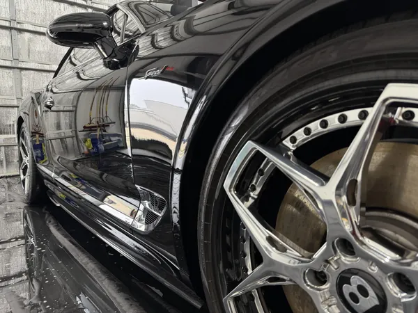 Black Bentley wheel and fender with a wet finish