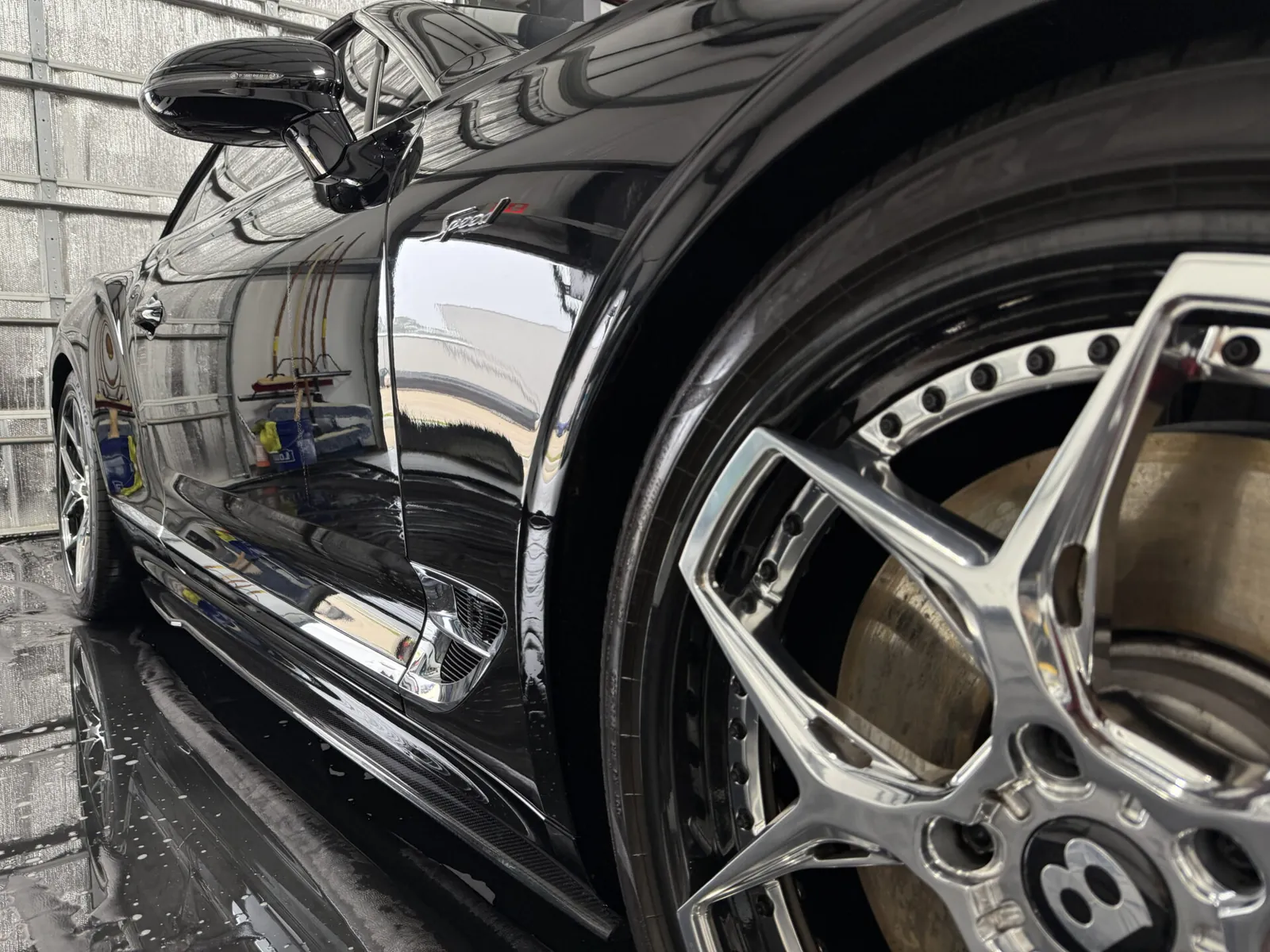Black Bentley wheel and fender with a wet finish