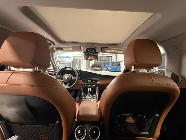 Brown leather interior under an open sunroof