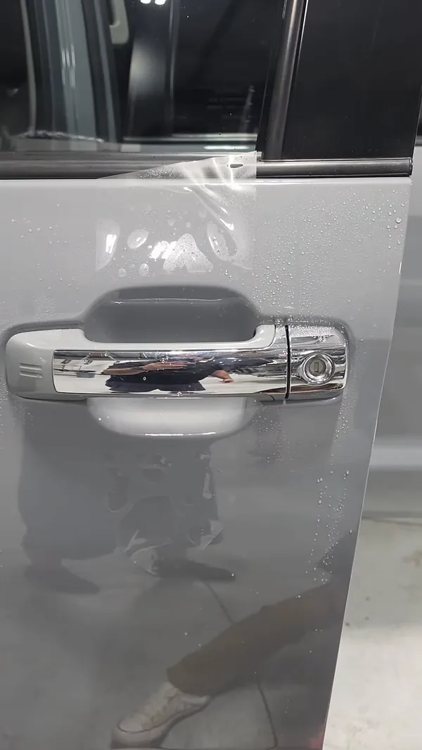 Paint protection film on a door handle cup