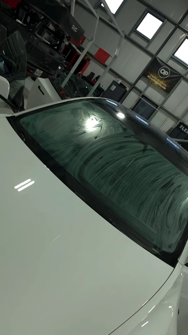 Tint film being set on a white Tesla windshield